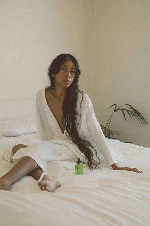 Hinu hair oil on bed with model