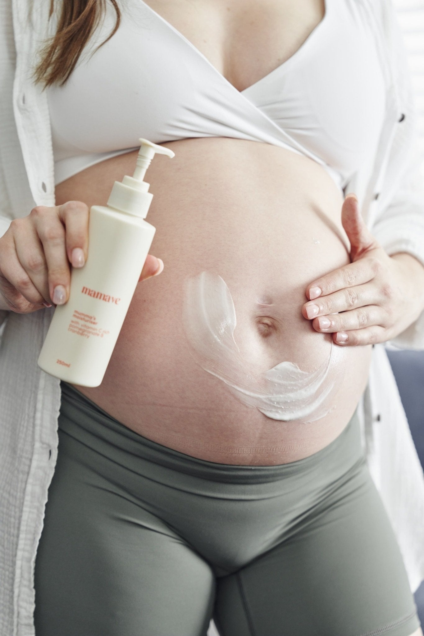 pregnant model applying mumma's body moisturiser