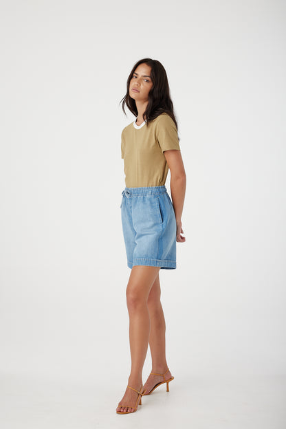 Outland Denim Eden Shorts in Bluejay hands behind model's back