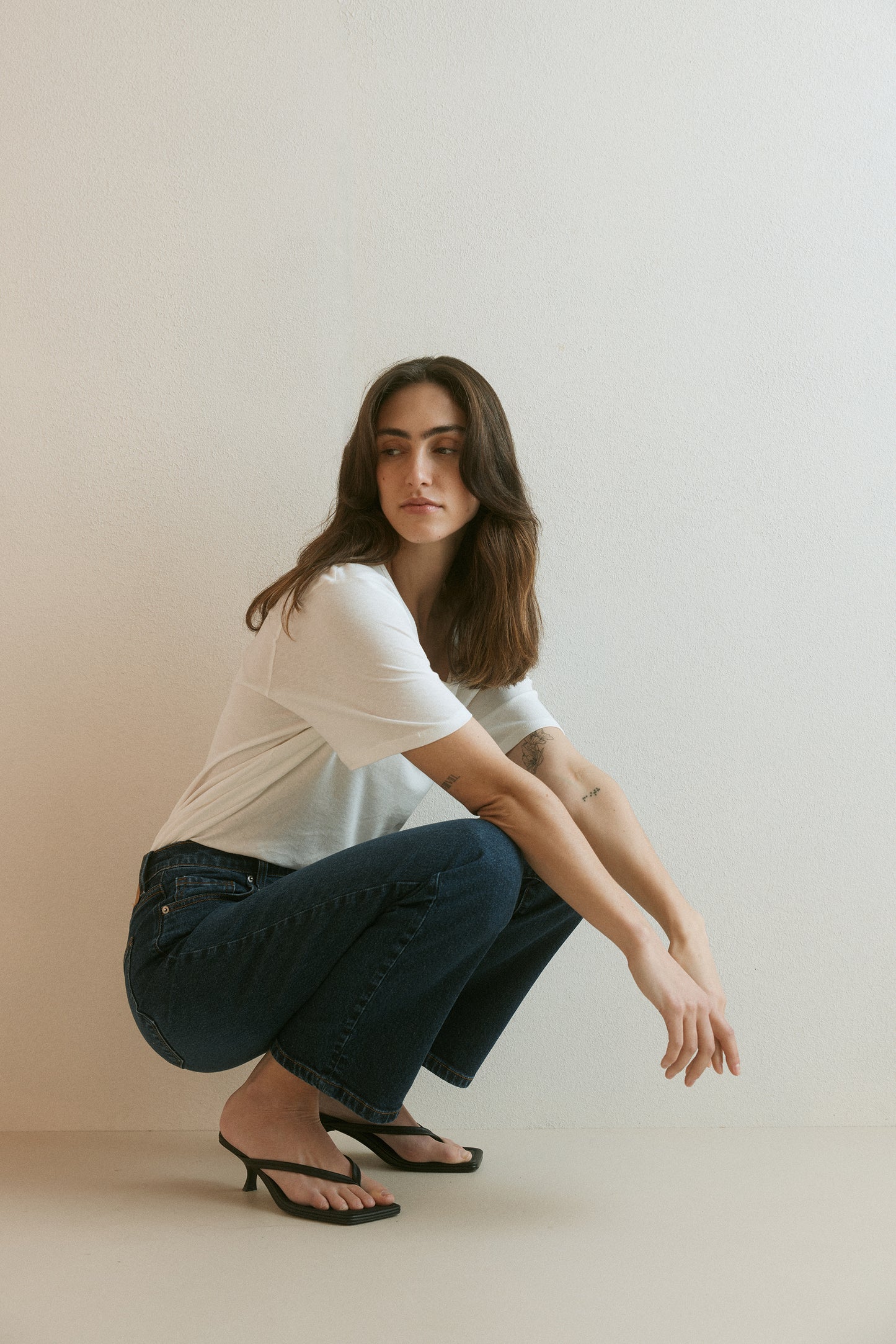 Outland Denim Lucy tee in white tucked – model sitting