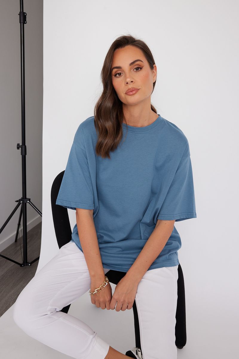 Alexandra women's Nix t-shirt in blue on stool 